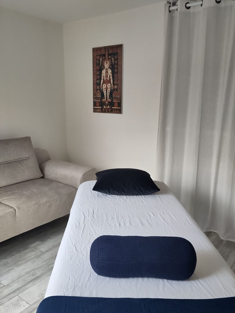 table-cabinet-1 Vue de la salle de soin à Clamart avec un table de massage et deux coussins